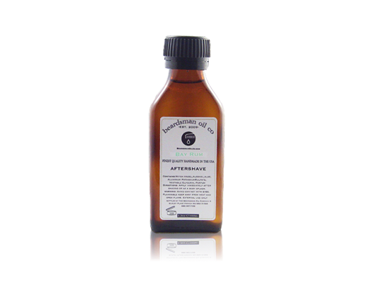 A small amber glass bottle of Beardsman Oil Co. Bay Rum Aftershave with a black ribbed cap and a white label, centered on a white background with a faint reflection below.