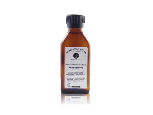 A small amber glass bottle of Beardsman Oil Co. Bay Rum Aftershave with a black ribbed cap and a white label, centered on a white background with a faint reflection below.
